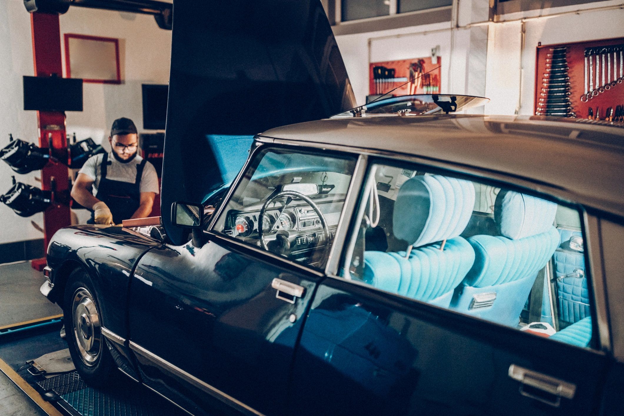 Technician working under the hood during an engine bay inspection