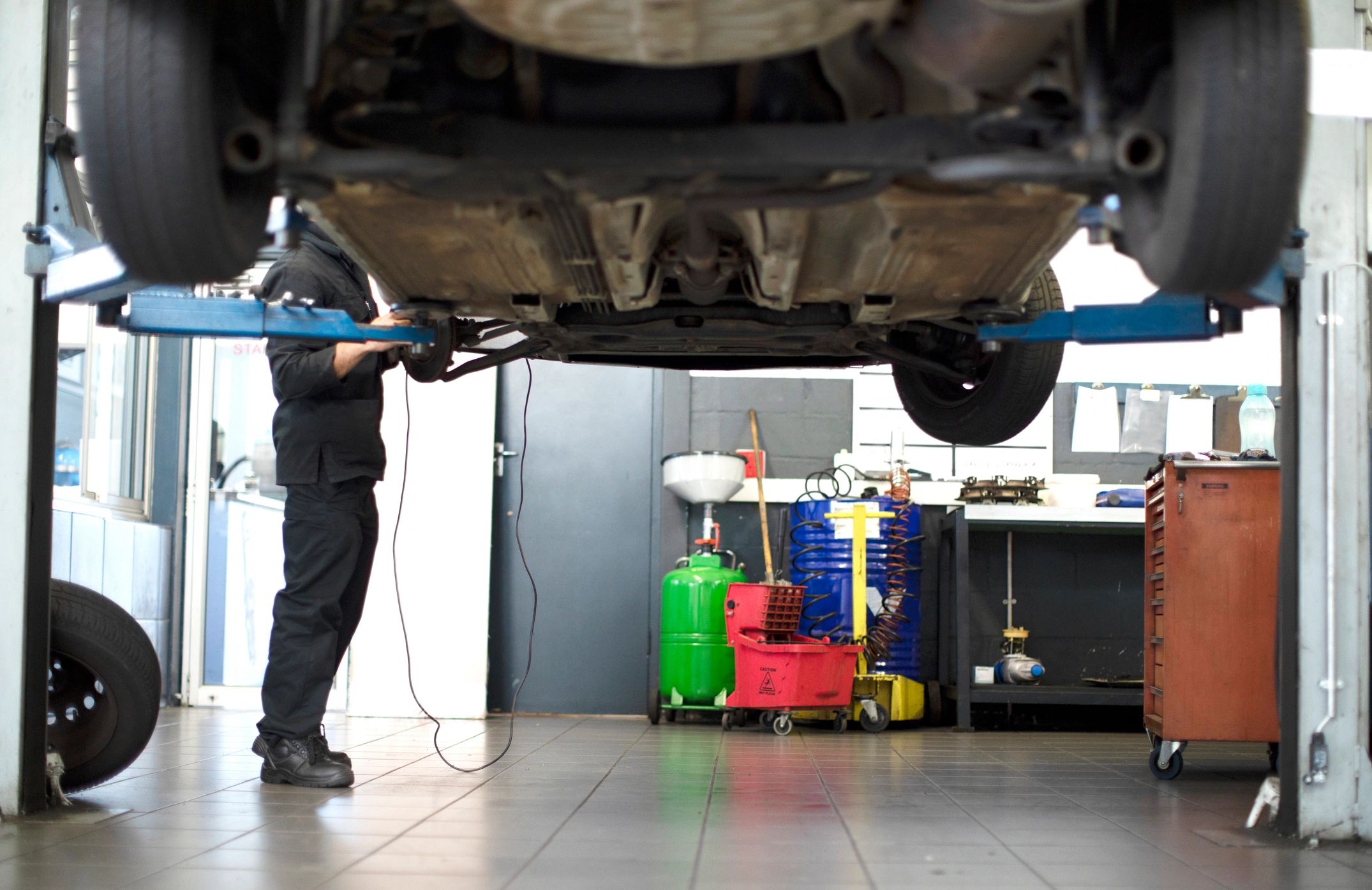 Technician inspecting a vehicle on a lift during a maintenance check