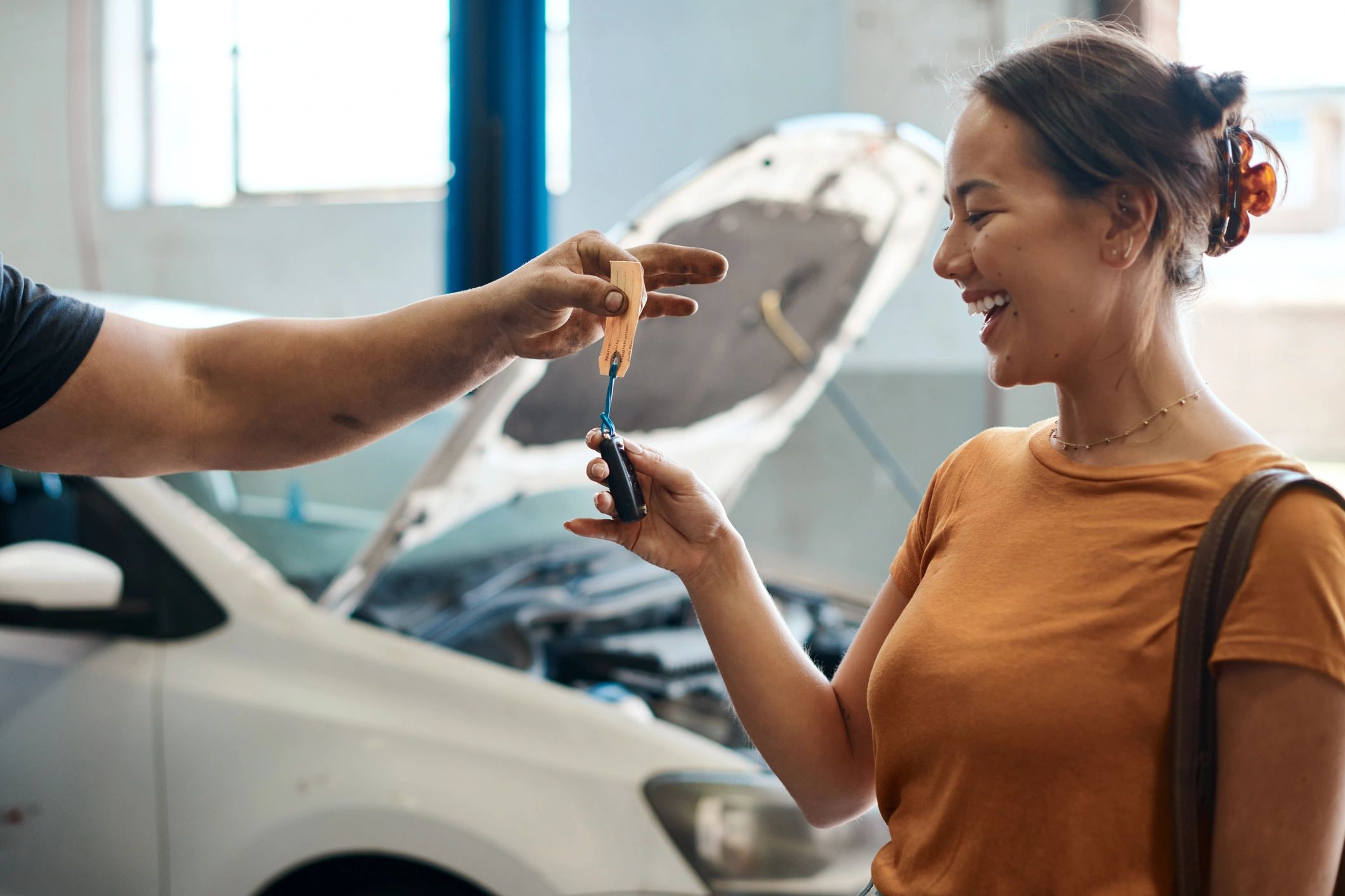 Customer receiving car keys at an auto repair shop