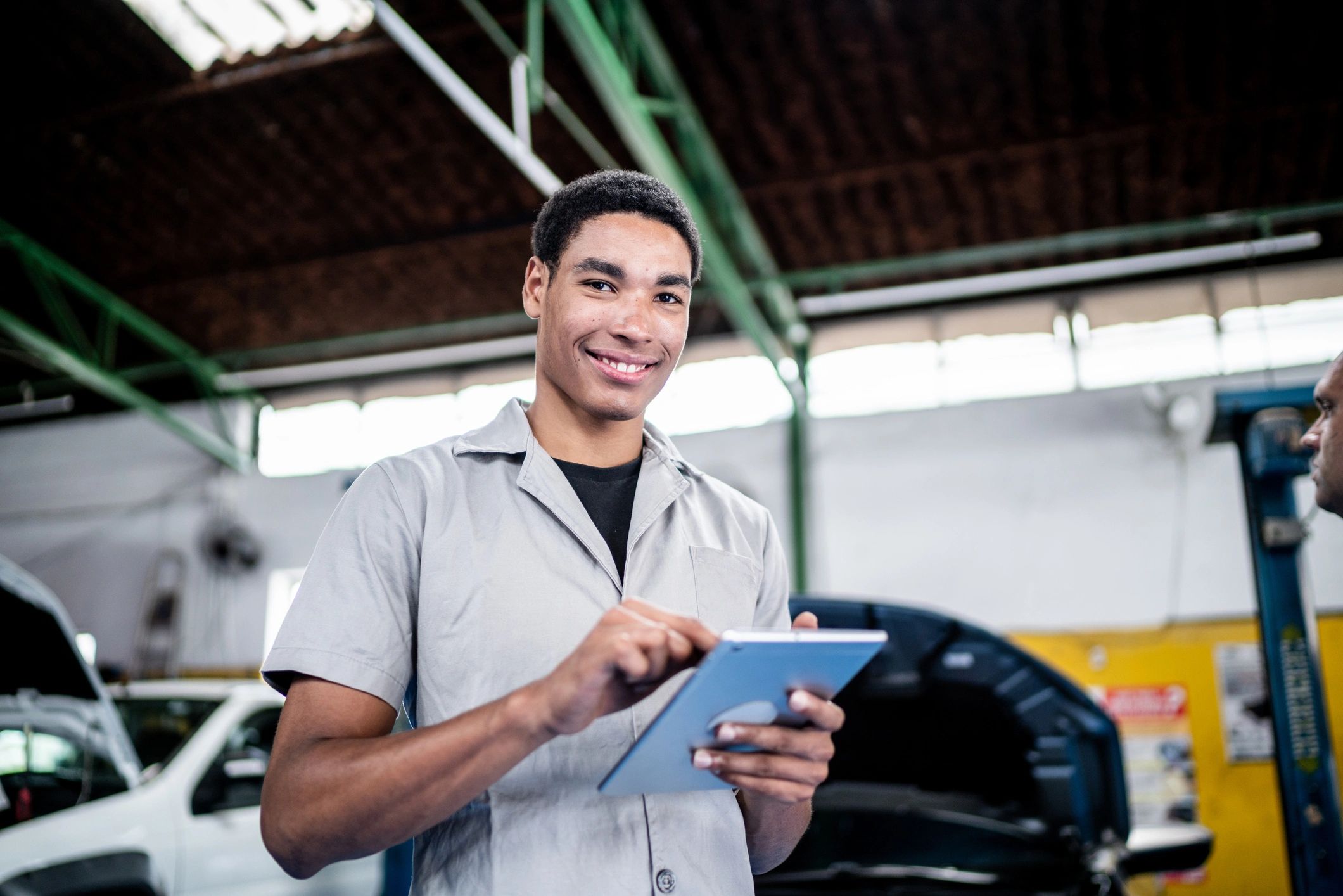 Technician reviewing a car maintenance checklist on a tablet in a service bay