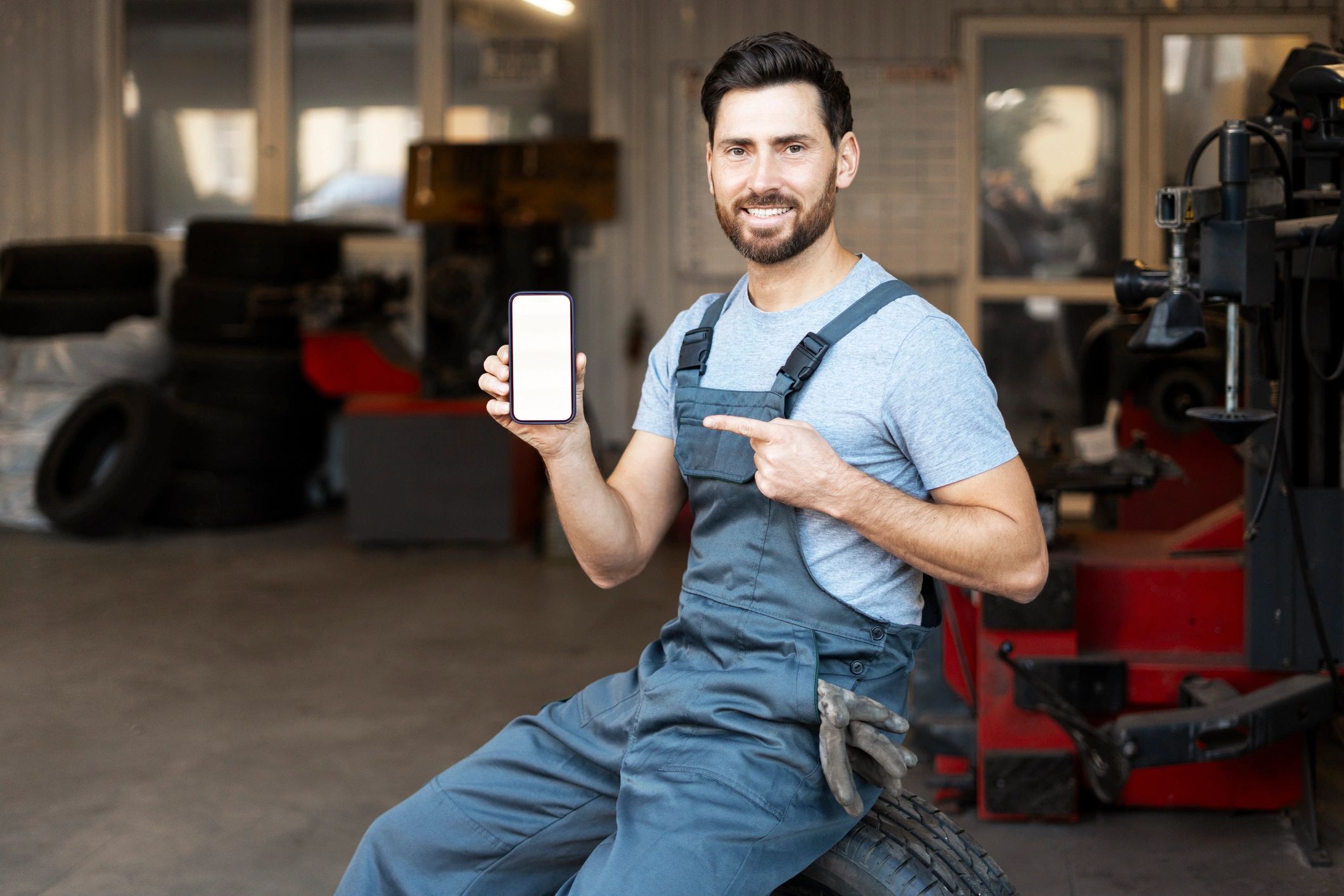 Mechanic showing a smartphone in an auto repair shop