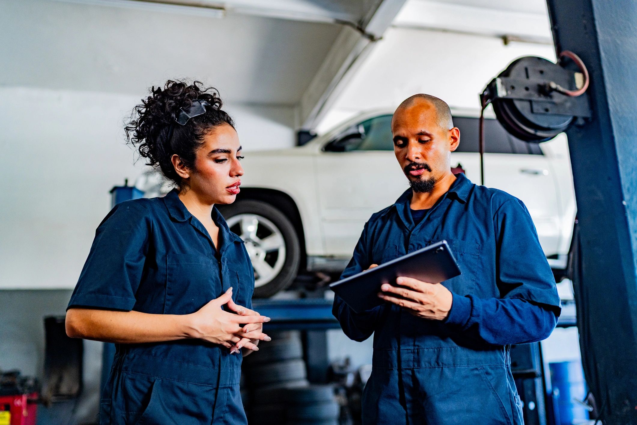 Service advisors and technicians discussing a vehicle in an auto repair shop