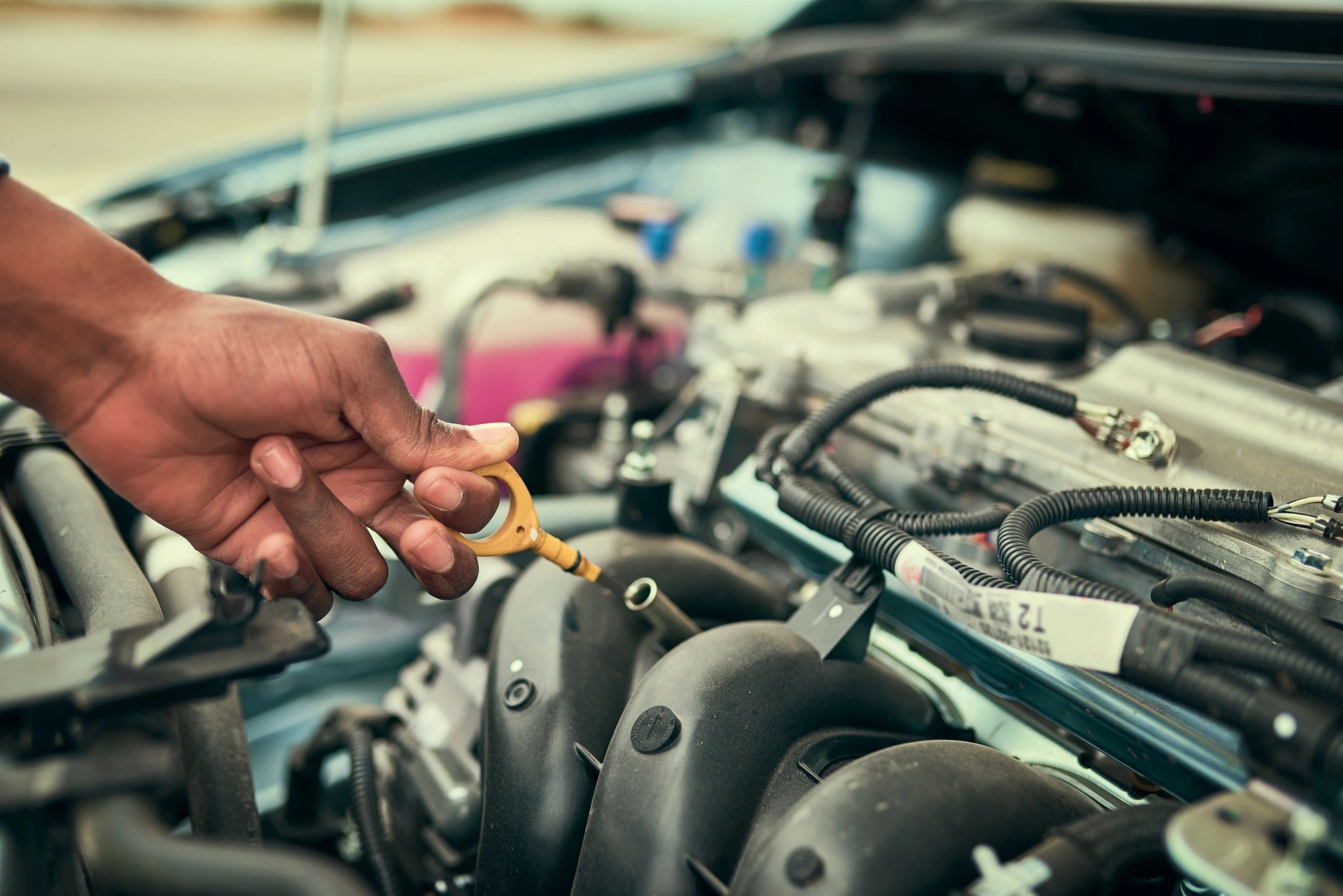 Technician checking vehicle fluids in the engine bay